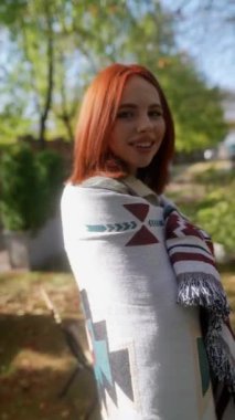 Aydınlık bir sonbahar gününde, şık ve güzel bir kızıl saçlı hippi elbiseli kız bahçe atmosferini zevkle yaşıyor. Yüksek kalite 4k görüntü