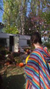 Güneşli bir sonbahar gününde elinde balkabağıyla hippi kıyafetli güzel bir genç kadın. Yüksek kalite 4k görüntü