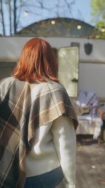 Aydınlık bir sonbahar gününde, şık ve güzel bir kızıl saçlı hippi elbiseli kız bahçe atmosferini zevkle yaşıyor. Yüksek kalite 4k görüntü