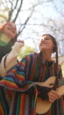 İki hippi meraklısı ukulele ile müzik yapıyor ve dans figürlerini sergiliyorlar. Yüksek kalite 4k görüntü