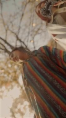 Hippi kıyafetli iki genç bayan sonbahar bahçesinde dans ediyorlar. Yüksek kalite 4k görüntü