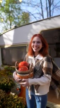 Sonbahar bahçesi, şık ve genç bir kızıl saçlının balkabağı sepetiyle güzel bir zemin hazırlıyor. Yüksek kalite 4k görüntü