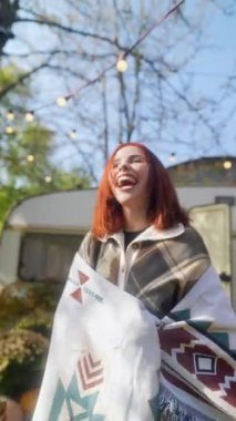 Sonbahar güneşini kucaklayan, hippi kostümlü çarpıcı kızıl saçlı kız bahçedeki hoş havanın tadını çıkarıyor. Yüksek kalite 4k görüntü