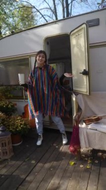 Sıcak bir günde, şık ve hippi kıyafetli güzel bir kadın sıcak bir içkiyi yudumlarken bir karavanda hayat hakkında konuşur. Yüksek kalite 4k görüntü