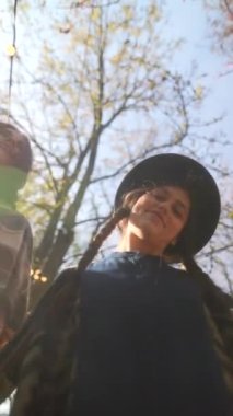 Hippi kıyafetli iki genç bayan sonbahar bahçesinde dans ediyorlar. Yüksek kalite 4k görüntü