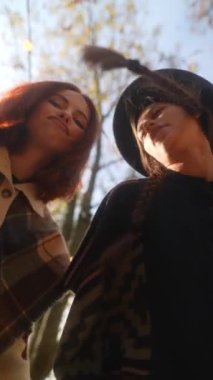 Hippi gibi giyinmiş bir çift genç kız sonbahar bahçesinde dans ediyorlar. Yüksek kalite 4k görüntü