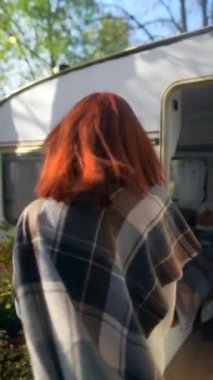 Sonbahar bahçesinde, güzel ve genç bir kızıl saçlı bir sepet balkabağı taşıyor. Yüksek kalite 4k görüntü