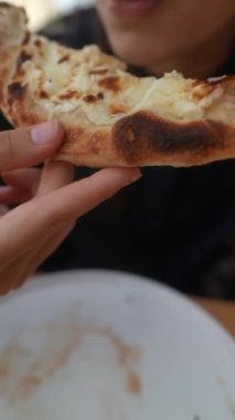 Sonbahar modasında, çarpıcı bir bayan açık terasta pizzadan zevk alır. Yüksek kalite 4k görüntü