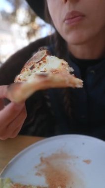 Bir pizzacı, terasta yemek yerken sonbahar kıyafetiyle güzellik saçar. Yüksek kalite 4k görüntü