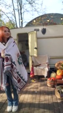 Sonbaharın güzelliğiyle çevrili, hippi kıyafetli bir kızıl bahçenin tadını çıkarıyor. Yüksek kalite 4k görüntü