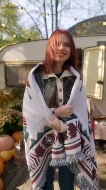 Kestane rengi bukleleriyle, hippi kostümlü güzel bir bayan sonbahar bahçesinin tadını çıkarıyor. Yüksek kalite 4k görüntü