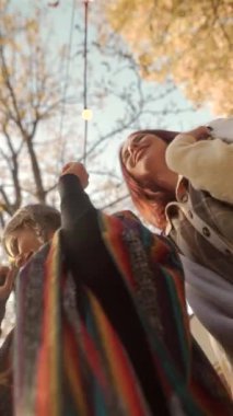 Hippi kıyafetli iki genç dansçı sonbahar bahçesinde dans ediyorlar. Yüksek kalite 4k görüntü