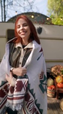 Kestane rengi bukleleriyle, hippi kostümlü güzel bir bayan sonbahar bahçesinin tadını çıkarıyor. Yüksek kalite 4k görüntü