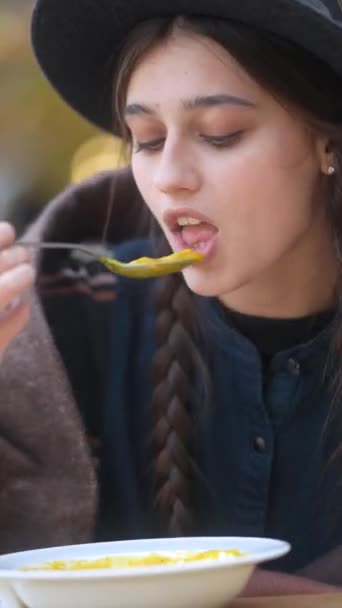 秋の服を着た活発な若い女性は 屋外テラスで彼女の食事を楽しんでいます 高品質の4K映像 — ストック動画