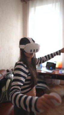 VR kulaklıkla, genç bir bayan evinde video oyunu oynuyor. Yüksek kalite 4k görüntü