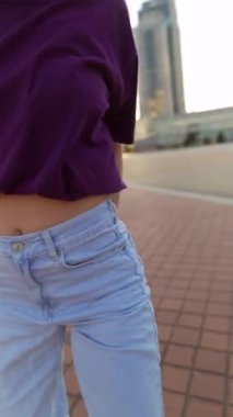 Şehir merkezi meydanı, kulaklıklı güzel kızıl saçlı bir kızın dansıyla aydınlanıyor. Yüksek kalite 4k görüntü