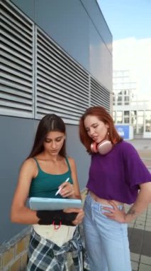 İki genç kadın aktif olarak şehir sokaklarında önemli bir konuyu tartışıyor. Yüksek kalite 4k görüntü