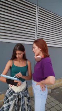 İki genç bayan, şehrin sokaklarında önemli bir konu hakkında konuşmaya dalmış durumdalar. Yüksek kalite 4k görüntü