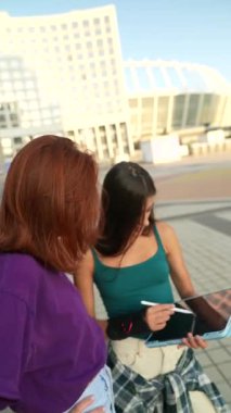 Parlak, genç arkadaşlar şehir meydanındaki yaz gününün tadını çıkarın. Yüksek kalite 4k görüntü