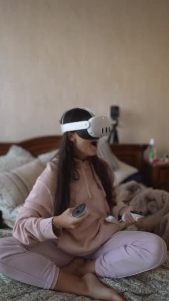 一位可爱的女士喜欢电子游戏 穿着粉色睡衣和Vr耳机 高质量的4K镜头 — 图库视频影像
