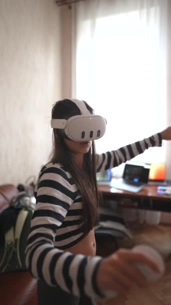 Vrヘッドセットを使用すると 若い女性が自宅でビデオゲームをプレイします 高品質の4K映像 — ストック動画