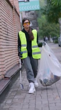 Şehir temizliğiyle uğraşan bir kız gönüllü olarak çöp toplayıcılarını kullanıyor. Yüksek kalite 4k görüntü