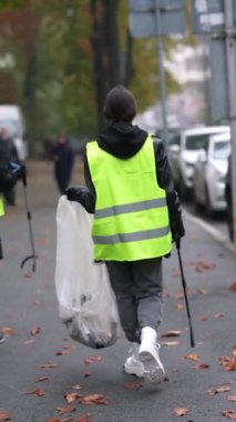 Temizleyicinin arkasından bakıldığında sonbahar şehir sokaklarının çöplerden temizlendiğini görüyoruz. Yüksek kalite 4k görüntü