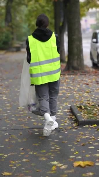 从后面拍摄 看门人收集垃圾在秋天的城市街道上 高质量的4K镜头 — 图库视频影像