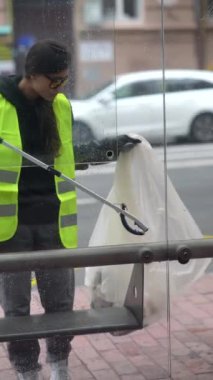 Dışarıdaki çöpleri toplamak için özel üniformalı canlı genç bir bayan gönüllü. Yüksek kalite 4k görüntü