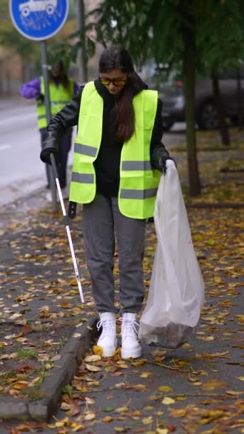 一名年轻姑娘穿着特殊的衣服 在秋天的城市街道上清扫垃圾 高质量的4K镜头 — 图库视频影像