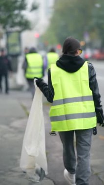Temizlik işçileri şehrin sonbahar sokaklarındaki çöpleri temizliyor. Yüksek kalite 4k görüntü