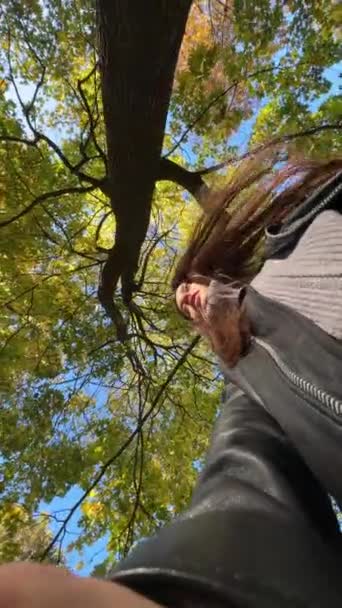 低い角度から木の枝の映像をキャプチャする秋の公園の優雅な女性 高品質の4K映像 — ストック動画