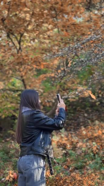 秋の公園を歩いている若い女性の背中から撮影 高品質の4K映像 — ストック動画