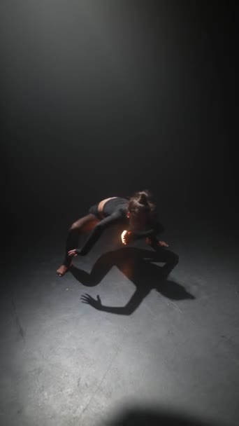振付師の若い女性が 薄暗く照らされたスタジオでダンスを披露します 高品質の4K映像 — ストック動画