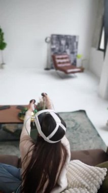 Noel ağaçlarının arasında, güzel bir kadın sanal gerçeklik kulaklığı kullanarak sohbet ediyor. Yüksek kalite 4k görüntü