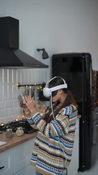 在一个圣诞装饰的厨房里 一位年轻女子戴着虚拟现实的眼镜做饭 高质量的4K镜头 — 图库视频影像
