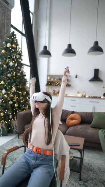 在圣诞节假期里 一个可爱的女人正在玩电子游戏 她用一个虚拟现实耳机 高质量的4K镜头 — 图库视频影像