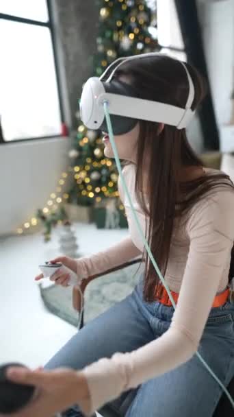 クリスマスのお祭りの最中に 仮想現実のヘッドセットを使用してビデオゲームをプレイする女性 高品質の4K映像 — ストック動画