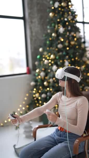 在圣诞树的喜庆气氛中 一位年轻而时髦的女士使用了一个虚拟现实耳机 高质量的4K镜头 — 图库视频影像