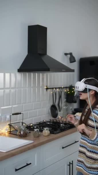 一位戴着虚拟现实眼镜的年轻女子在一个圣诞主题厨房里准备食物 高质量的4K镜头 — 图库视频影像