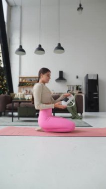 Yogaya dalmış, yoga minderinde pembe etek giyerken sanal gerçeklik kulaklığı takıyor. Yüksek kalite 4k görüntü