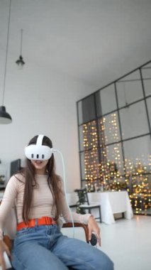Bir kadın Noel tatilini sanal gerçeklik kulaklığı kullanarak video oyunu oynayarak geçirir. Yüksek kalite 4k görüntü