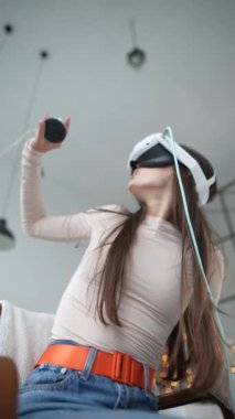Şenlikli Noel tatili sırasında bir kadın sanal gerçeklik kulaklığı kullanarak bir video oyununa daldı. Yüksek kalite 4k görüntü