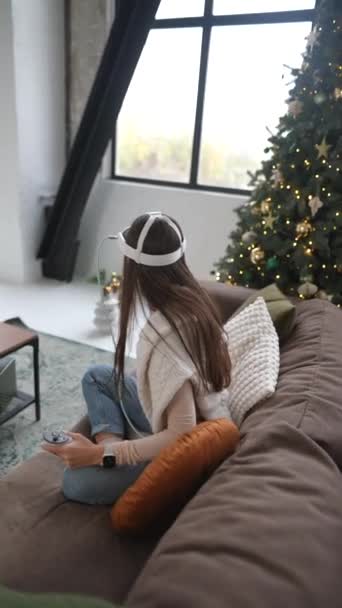Юная Леди Сидящая Рождественской Елки Наслаждается Игрой Через Гарнитуру Виртуальной — стоковое видео