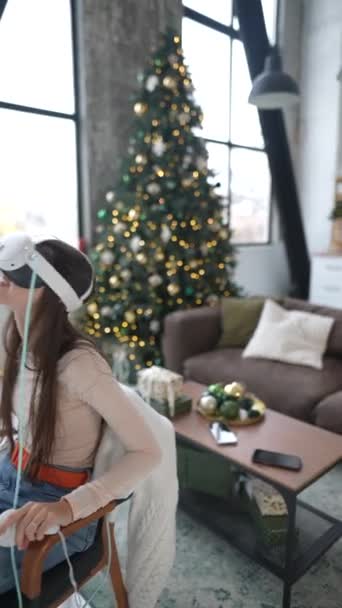 Среди Рождественских Праздников Красивая Женщина Наслаждается Видеоигрой Гарнитурой Виртуальной Реальности — стоковое видео