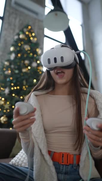 クリスマスの精神では 楽しい若い女性が彼女の贈り物 仮想現実のヘッドセットを調べます 高品質の4K映像 — ストック動画