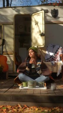 Sonbahar günü güneşli bir karavanın yanında hippi kıyafetli, modaya uygun, genç bir kız. Yüksek kalite 4k görüntü
