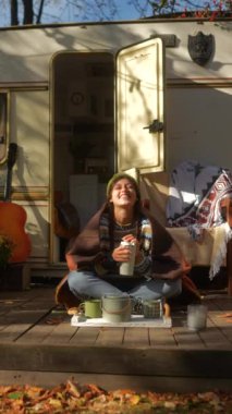 Sonbahar günü güneşli bir karavanın yanında hippi kıyafetli moda düşkünü genç bir bayan. Yüksek kalite 4k görüntü