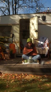 Bir sonbahar günü güneşli bir karavanın yanında hippi görünümünü sallayan şık, genç bir bayan. Yüksek kalite 4k görüntü