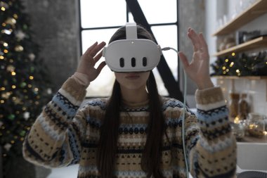 Noel mutfağı, şık ve güzel bir kızın sanal gerçeklik kulaklığı kullanarak yemek pişirdiği yerdir. Yüksek kalite fotoğraf